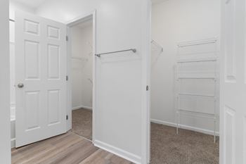 An empty bedroom with a closet and a white door